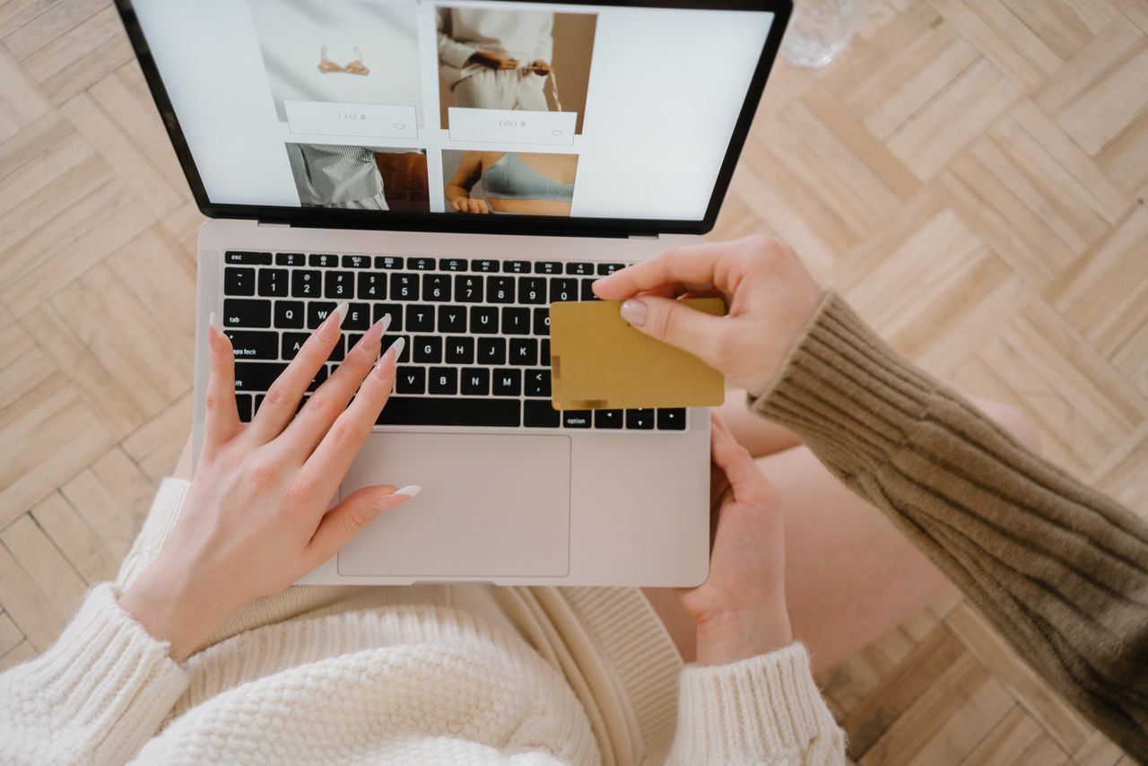 creative Person shopping online using a laptop and credit card, highlighting e-commerce convenience.